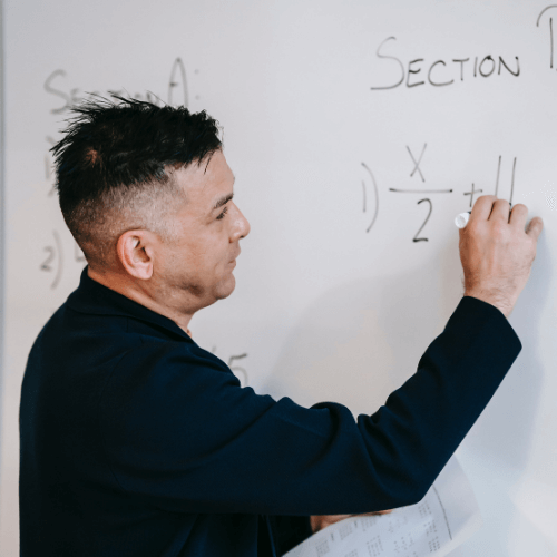 STEM teacher writing numbers on white board