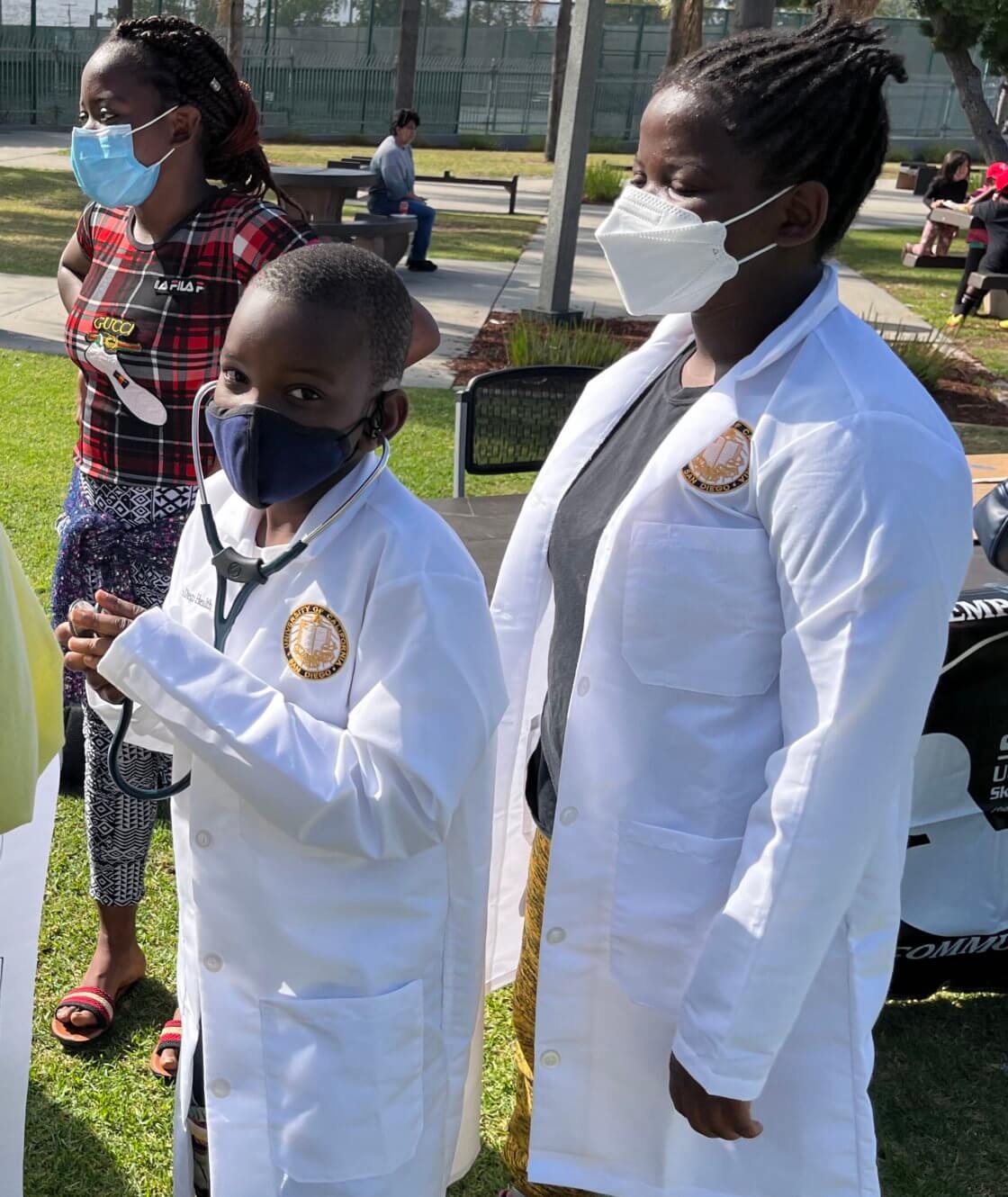 Two black students wearing lab gown, face mask and stethoscope
