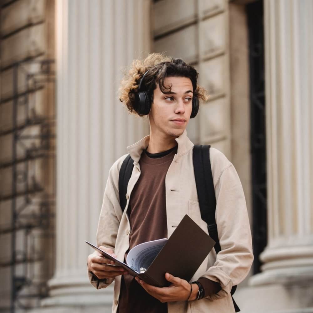 A scholar boy wearing headphone and holding a book